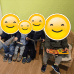 Kinder der Däumelinchen Kindertagesplege sitzen auf einer Bank